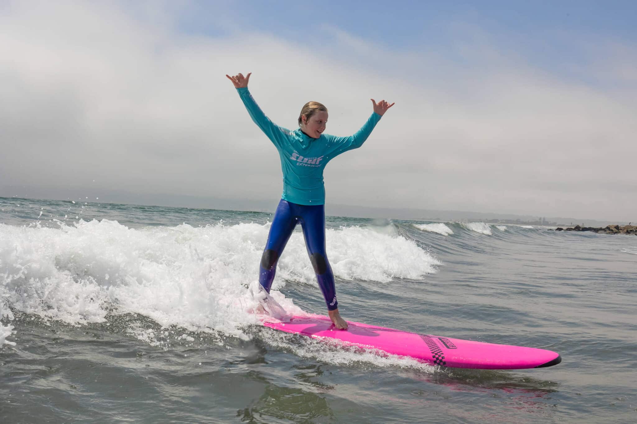 a young girl riding a wave on a surfboard in the water